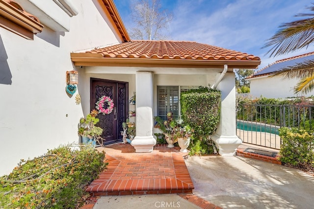 property entrance with a patio area and a fenced in pool