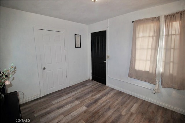 interior space with a healthy amount of sunlight, baseboards, and wood finished floors