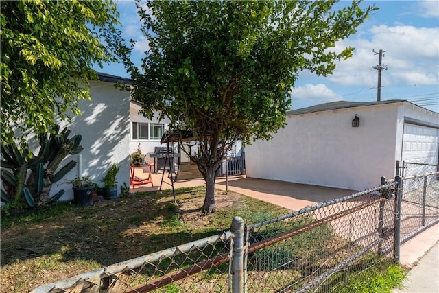 view of home's exterior with a garage, an outdoor structure, fence, and stucco siding