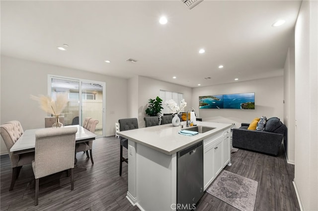 kitchen featuring a kitchen island with sink, a sink, open floor plan, light countertops, and dishwasher