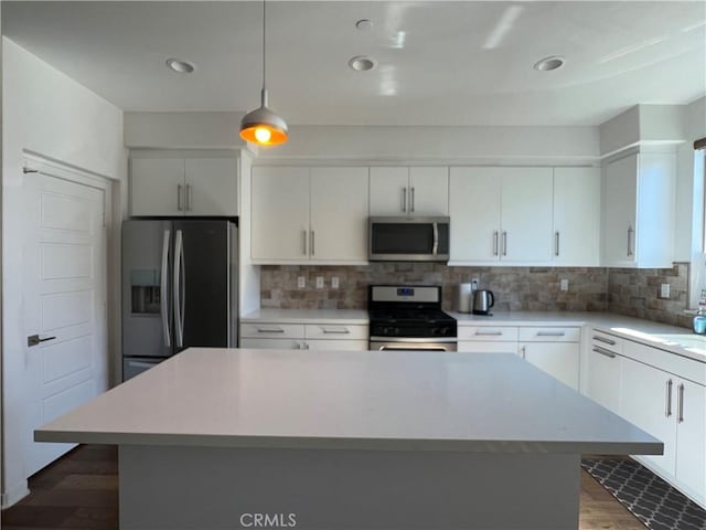 kitchen featuring stainless steel appliances, light countertops, and tasteful backsplash