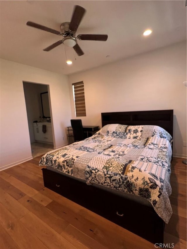 bedroom with recessed lighting, ensuite bathroom, baseboards, and wood finished floors