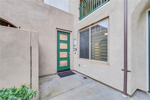 property entrance with a patio area and stucco siding