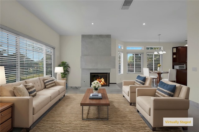 living room with a fireplace, a healthy amount of sunlight, and a notable chandelier