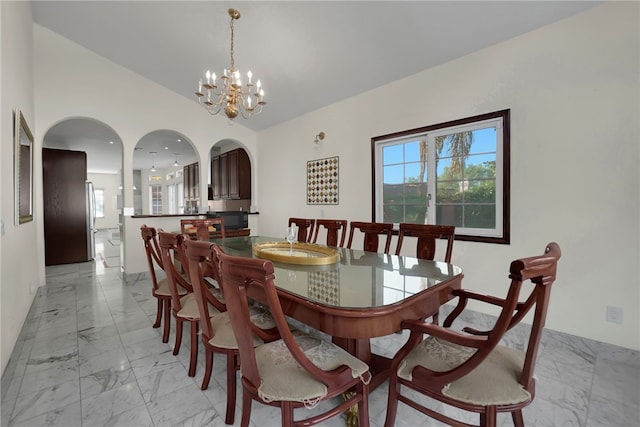 dining area featuring a notable chandelier and vaulted ceiling