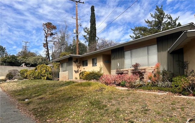 view of front of house featuring fence, a front lawn, and brick siding