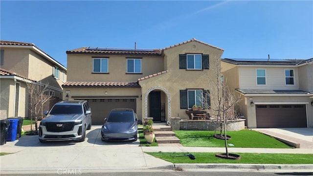 mediterranean / spanish-style home featuring a garage, solar panels, and a front yard