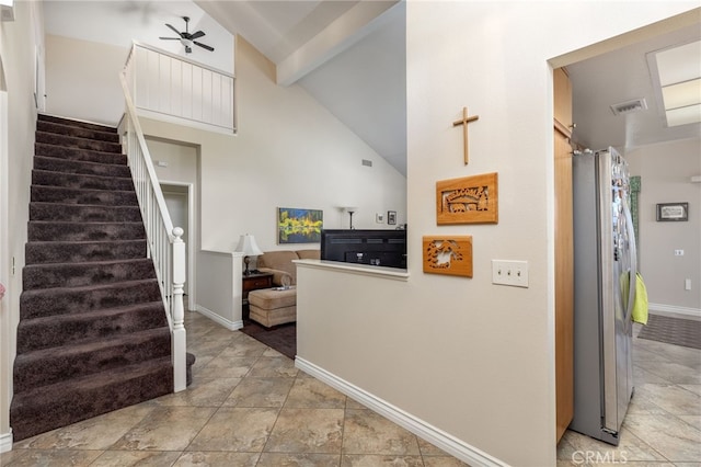 stairs with visible vents, beamed ceiling, high vaulted ceiling, baseboards, and ceiling fan