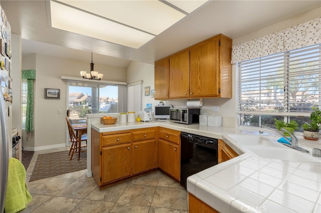 kitchen featuring brown cabinets, dishwasher, stainless steel microwave, a peninsula, and a notable chandelier