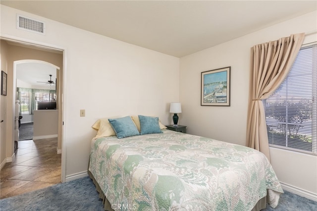 bedroom featuring arched walkways, baseboards, and visible vents