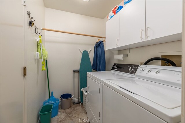 washroom with washer and dryer, light tile patterned flooring, and cabinet space