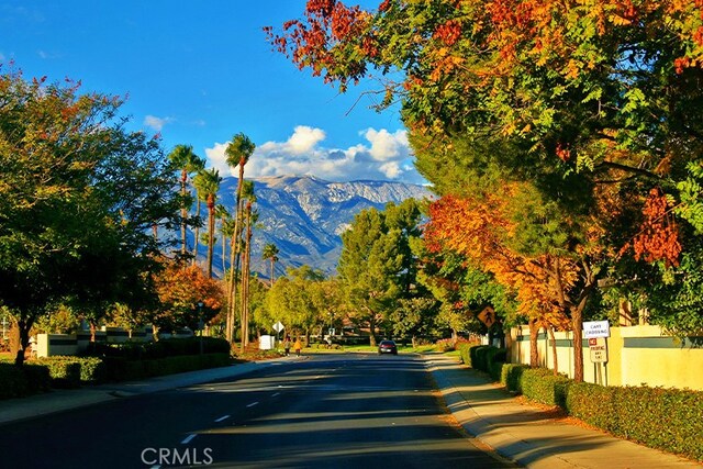 view of street featuring curbs, a mountain view, and sidewalks