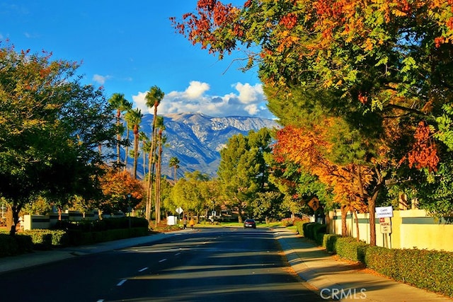 view of road with curbs, sidewalks, and a mountain view
