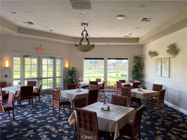 dining room featuring visible vents, a tray ceiling, and carpet