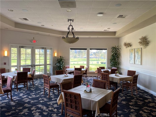 dining area with carpet floors, visible vents, a healthy amount of sunlight, and french doors