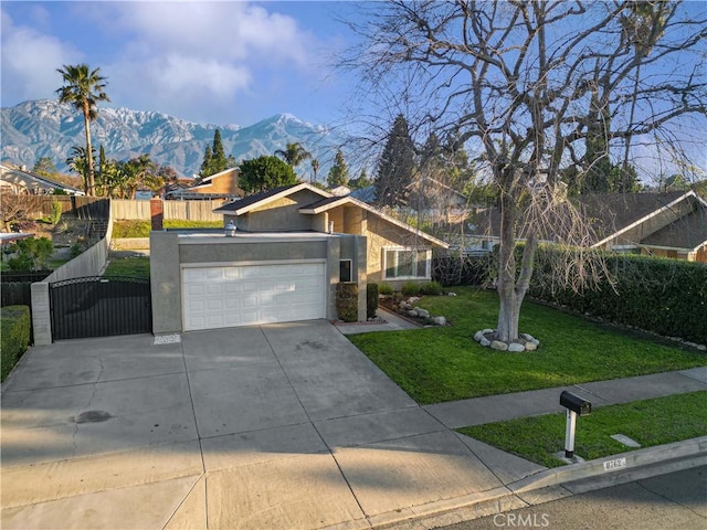 view of front facade with a mountain view, a front lawn, and a garage