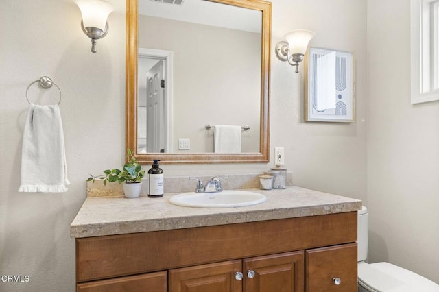 half bathroom with visible vents, toilet, and vanity