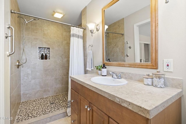 full bath with a tile shower and vanity