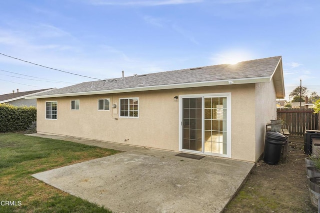 back of house featuring a patio, a shingled roof, and stucco siding