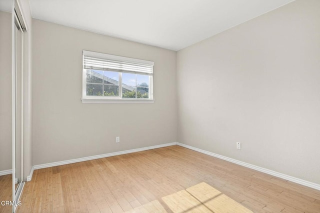 spare room with light wood-style floors and baseboards