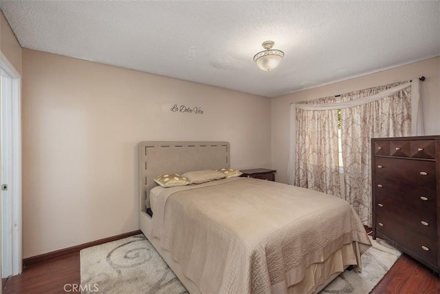 bedroom featuring dark hardwood / wood-style flooring and a textured ceiling