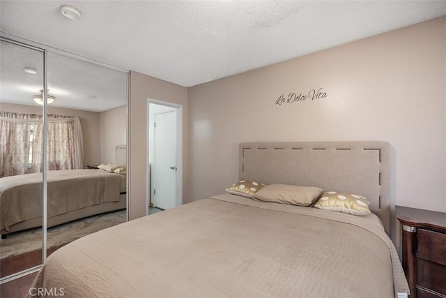 bedroom with a textured ceiling and a closet