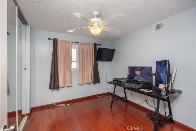 home office featuring a textured ceiling, ceiling fan, and dark hardwood / wood-style floors