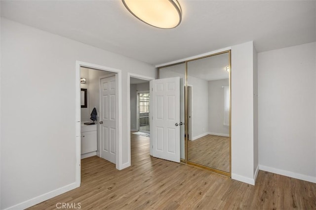 unfurnished bedroom with a closet and light hardwood / wood-style flooring