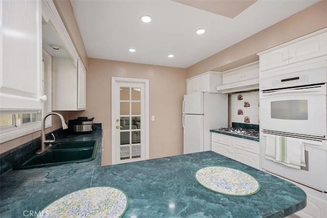 kitchen featuring white appliances, sink, white cabinetry, and tasteful backsplash