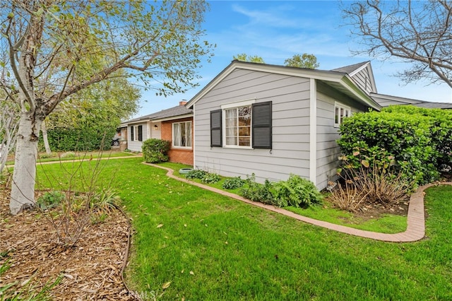 view of side of property with a lawn