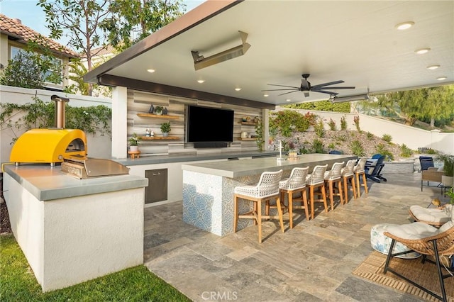 view of patio / terrace featuring area for grilling, an outdoor bar, and ceiling fan