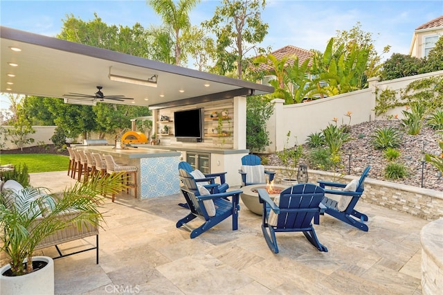 view of patio / terrace featuring ceiling fan, a fire pit, and a bar