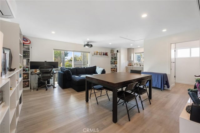 dining room featuring an AC wall unit, light hardwood / wood-style flooring, and sink