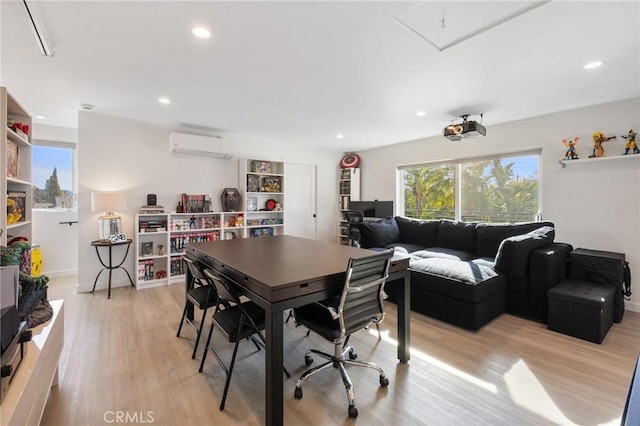 dining room with light hardwood / wood-style flooring and a wall unit AC