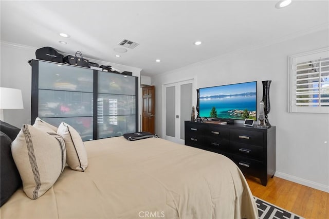 bedroom featuring ornamental molding and hardwood / wood-style flooring