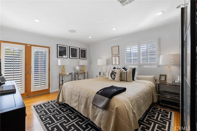 bedroom with light hardwood / wood-style floors, access to outside, crown molding, and french doors