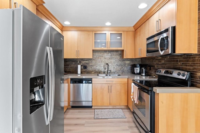 kitchen featuring light brown cabinets, a sink, light countertops, appliances with stainless steel finishes, and glass insert cabinets