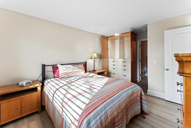 bedroom with light wood-style flooring and baseboards