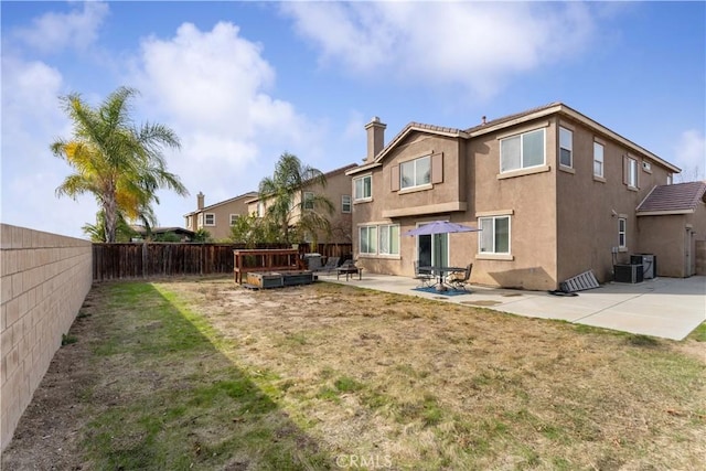 back of house with a yard, a patio area, a hot tub, and central AC