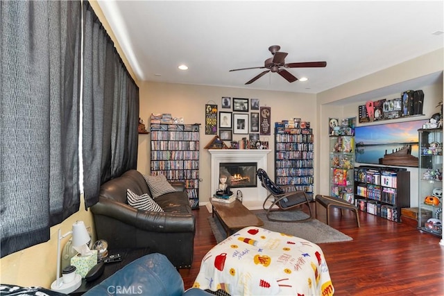 living room featuring ceiling fan and dark wood-type flooring