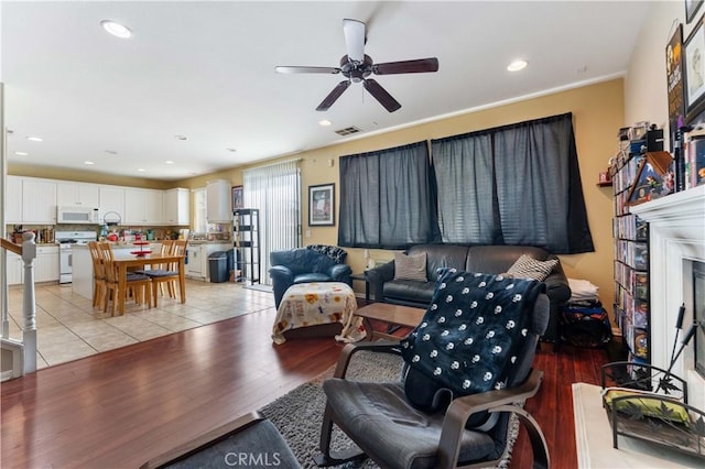 living room featuring light wood-type flooring and ceiling fan