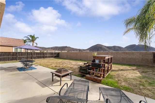 view of patio / terrace featuring a fire pit and a mountain view