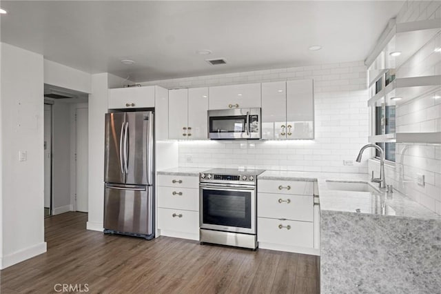 kitchen featuring stainless steel appliances, sink, white cabinets, dark hardwood / wood-style floors, and decorative backsplash