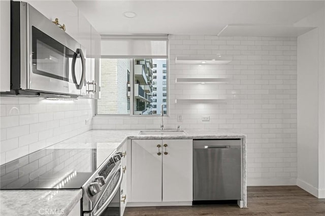 kitchen featuring sink, stainless steel appliances, white cabinets, and light stone counters