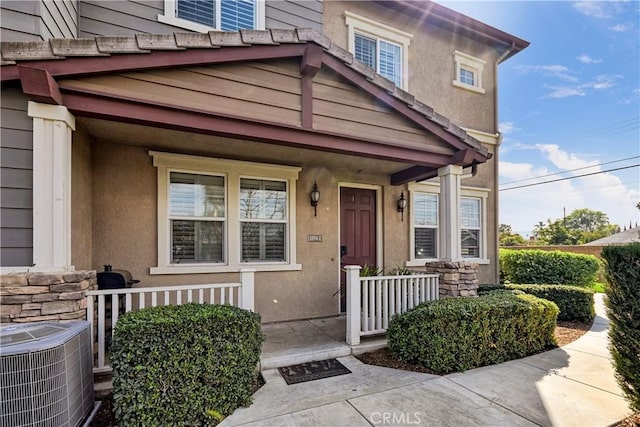 entrance to property with central AC and a porch