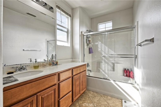 bathroom featuring tile patterned floors, vanity, and enclosed tub / shower combo