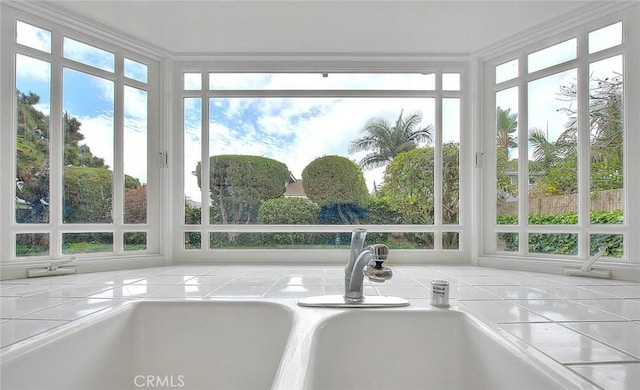 unfurnished sunroom with a sink and plenty of natural light