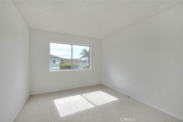 carpeted empty room featuring a textured ceiling