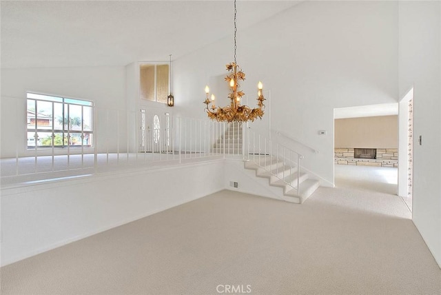 unfurnished room with stairs, a notable chandelier, high vaulted ceiling, and carpet flooring