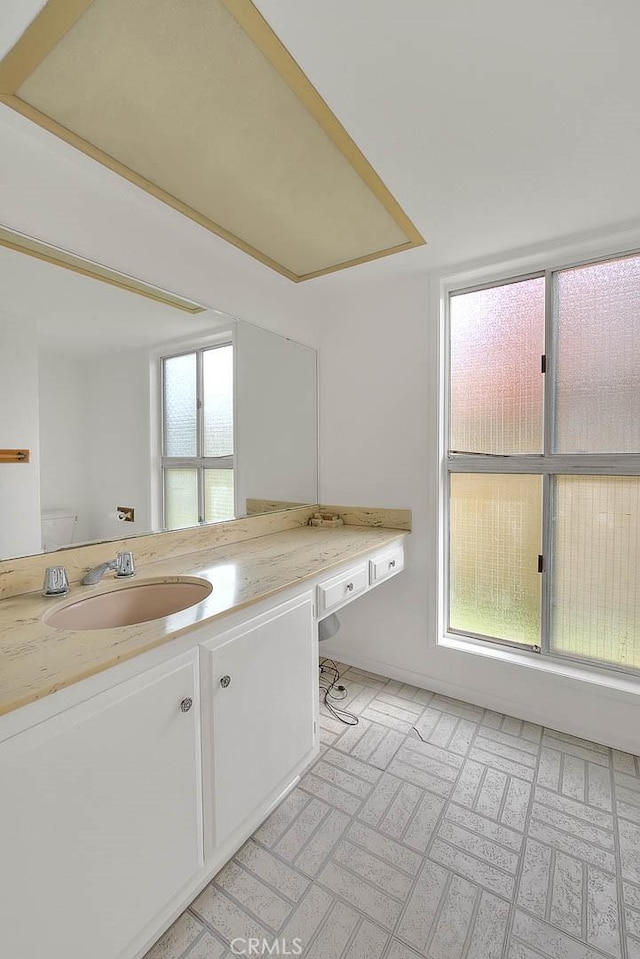 bathroom featuring a healthy amount of sunlight, vanity, and toilet